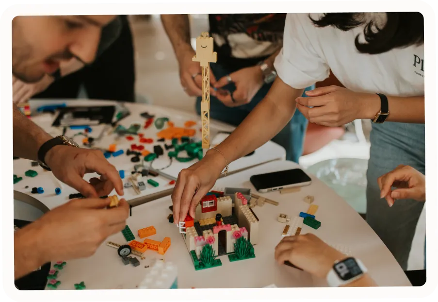 Photo of employees building a house with legos