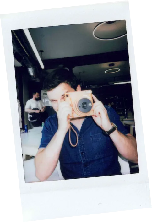 Polaroïd d'un employé prenant une photo avec un appareil photo polaroïd