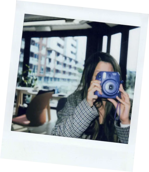 Polaroid of an employee taking a photo with a polaroid camera