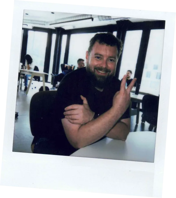 Polaroid of an employee making the peace sign with his hand