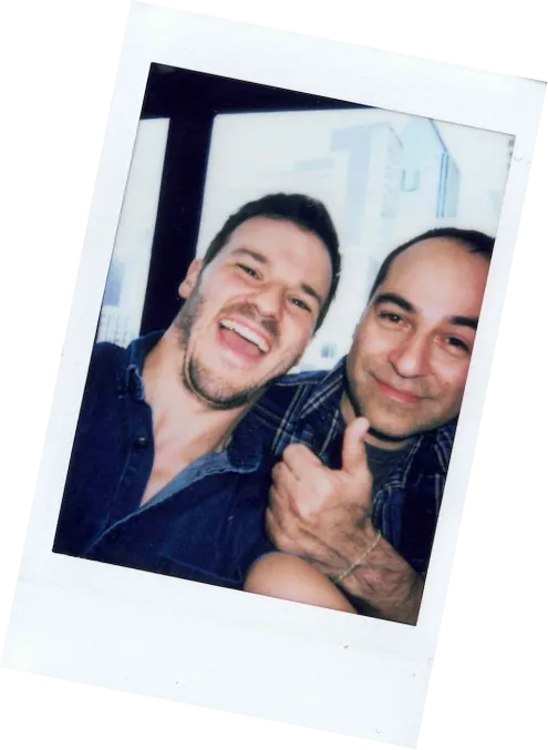 Polaroid of two employees smiling and making a thumbs up